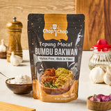 Pouch Tepung Mocaf Bumbu Bakwan 200 gram di meja dapur dengan bawang putih dan bawang merah