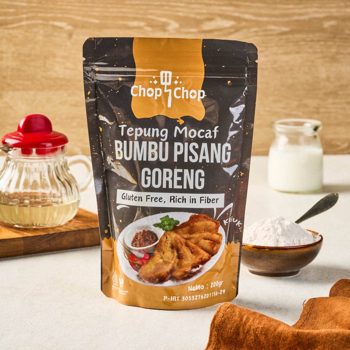 Pouch Tepung Mocaf Bumbu Pisang Goreng 200 gram di meja dapur dengan mangkuk tepung